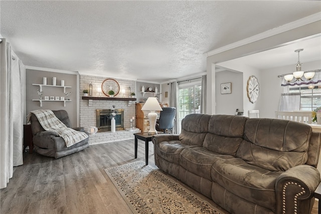 living area featuring a fireplace, wood finished floors, a textured ceiling, and ornamental molding