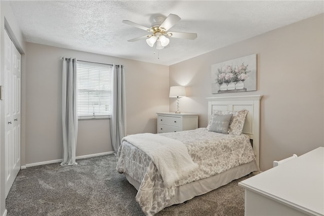 carpeted bedroom with ceiling fan, baseboards, a textured ceiling, and a closet
