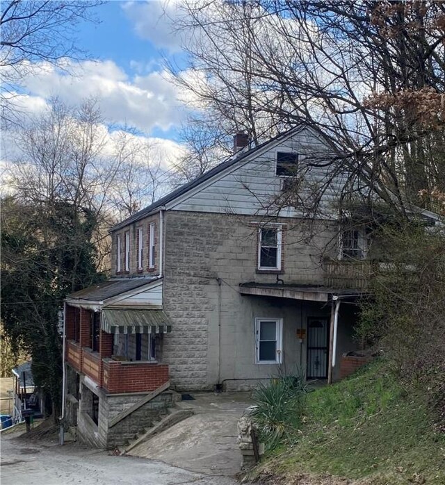 view of property exterior featuring stone siding and a chimney