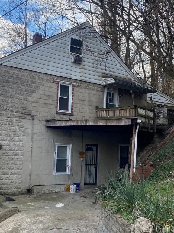 rear view of property featuring a patio and a chimney