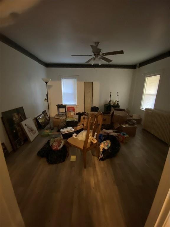 living room with crown molding, a ceiling fan, and wood finished floors