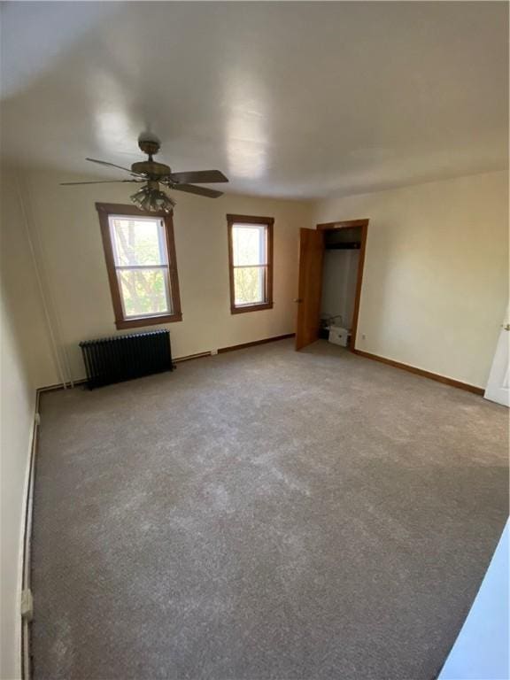 unfurnished bedroom featuring a ceiling fan, baseboards, light carpet, and radiator