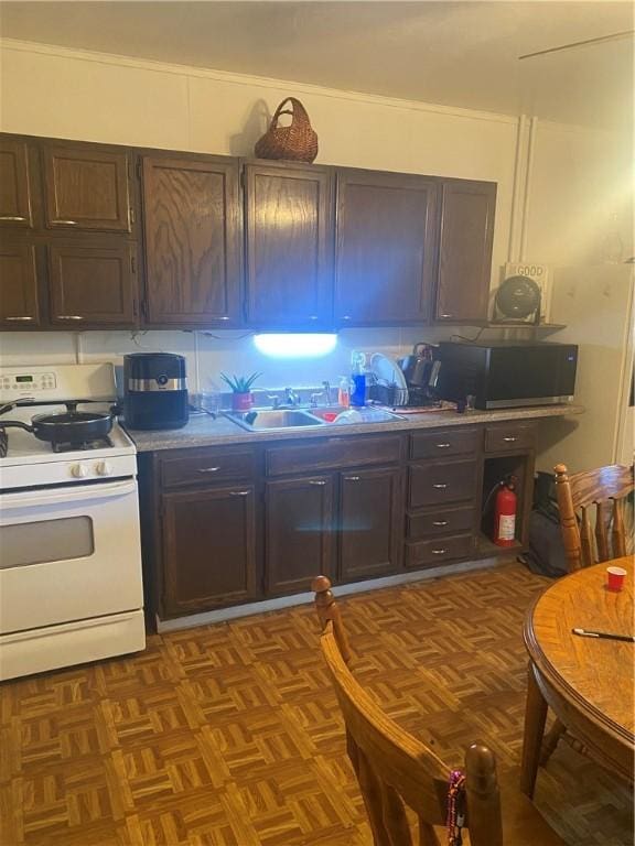 kitchen featuring dark brown cabinets, stainless steel microwave, and white range with gas cooktop