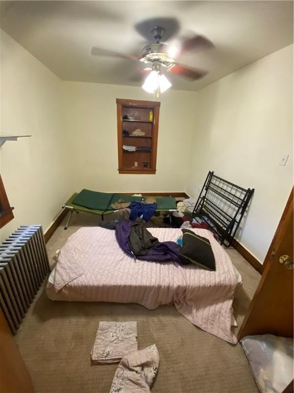 carpeted bedroom with radiator, ceiling fan, and baseboards