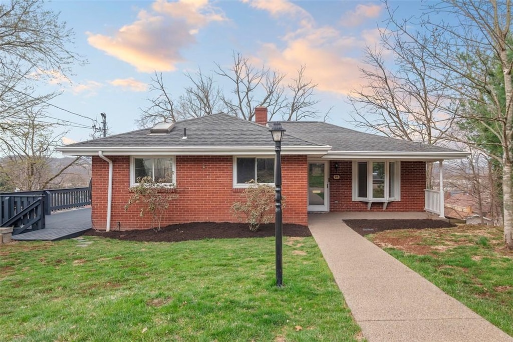 95 Plainfield Ave, Emsworth, PA 15202 - view of front of property with a lawn, covered porch, brick siding, a shingled roof, and a chimney