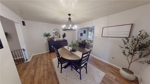 dining room with a chandelier, wood finished floors, and baseboards