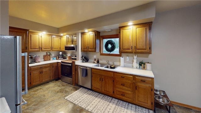 kitchen with stainless steel appliances, a sink, light countertops, and brown cabinetry
