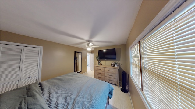 bedroom with a closet, light carpet, and ceiling fan