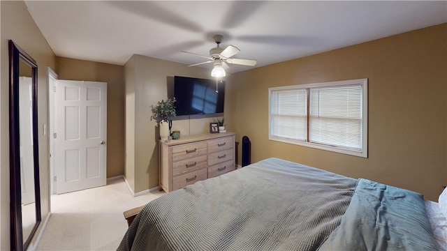 bedroom with light carpet, a ceiling fan, and baseboards