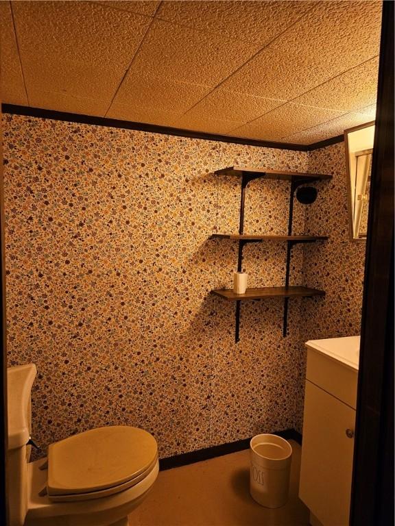 half bath featuring vanity and toilet