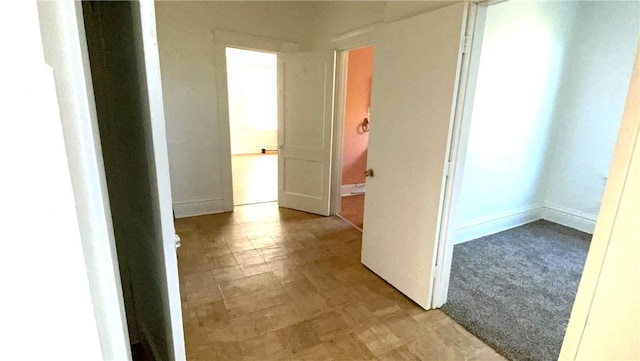hall with tile patterned floors