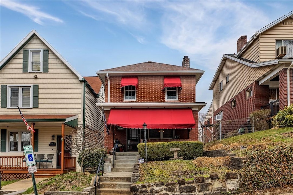 2107 Columbia Ave, Swissvale, PA 15218 - view of front of property with covered porch, brick siding, and a chimney