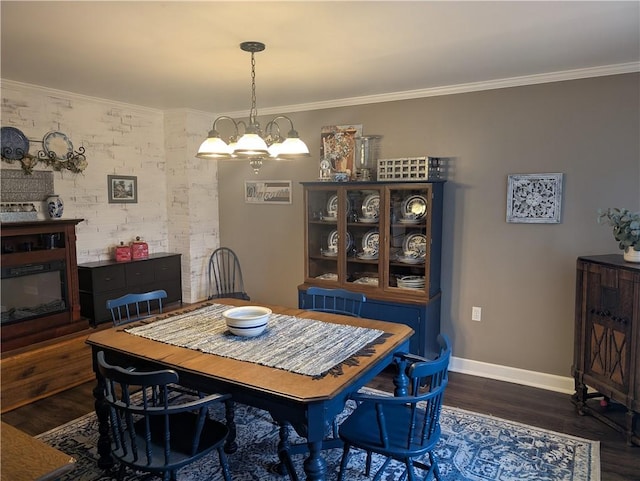 dining area featuring wood finished floors, baseboards, ornamental molding, and a chandelier