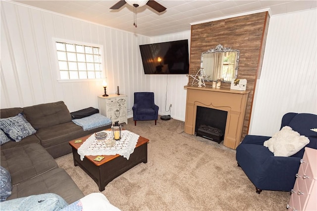 living room with ornamental molding, a ceiling fan, light colored carpet, a fireplace, and baseboards