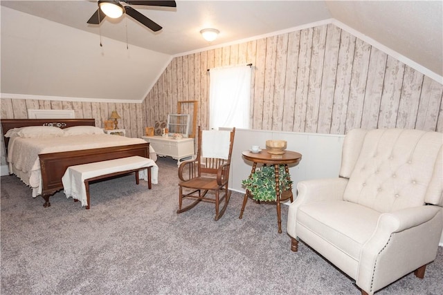 carpeted bedroom featuring lofted ceiling, wooden walls, and ceiling fan
