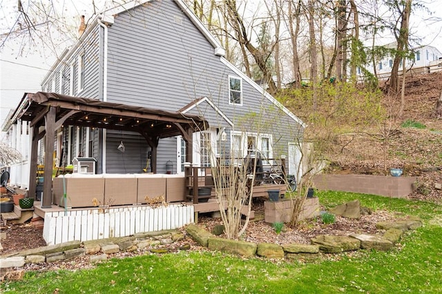 back of property with a deck, an outdoor living space, and a gazebo
