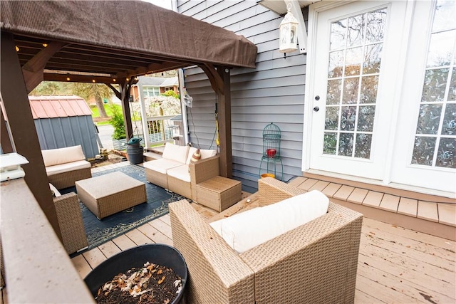 deck featuring an outdoor living space with a fire pit