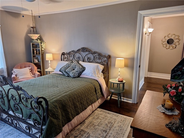 bedroom featuring wood finished floors, baseboards, and crown molding