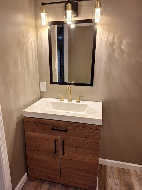 bathroom with wood finished floors, baseboards, and vanity