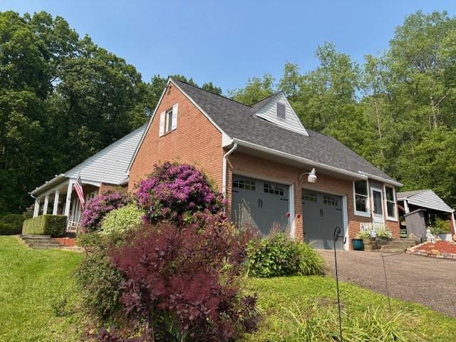 612 Freeport Rd, South Buffalo Twp, PA 16229 - view of property exterior featuring brick siding, a garage, a lawn, and driveway