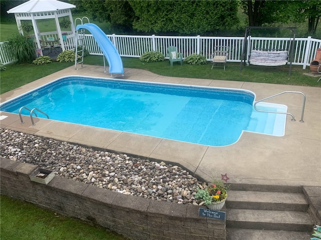 view of pool with a fenced in pool, fence, and a water slide