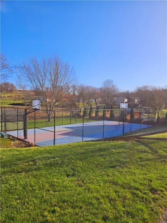 view of sport court featuring a yard, fence, and community basketball court