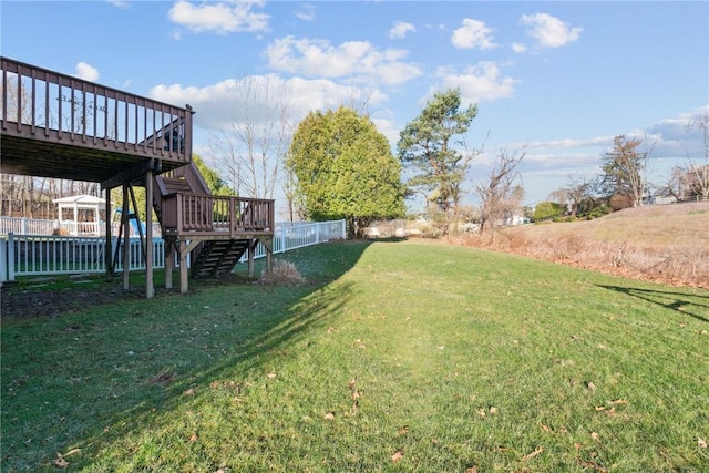 view of yard featuring a wooden deck, fence, and stairway