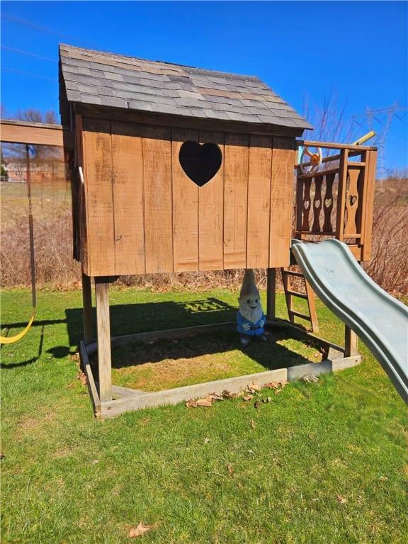 view of jungle gym with an outdoor structure and a lawn