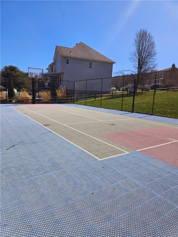 view of basketball court featuring community basketball court, fence, and a yard