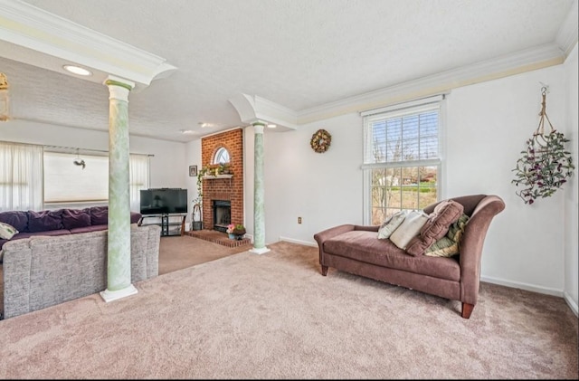 living room featuring crown molding, decorative columns, a fireplace, and carpet floors