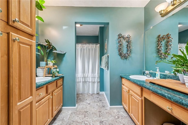 bathroom with two vanities, baseboards, a sink, and a shower with curtain