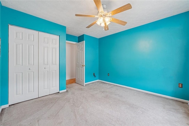 unfurnished bedroom featuring ceiling fan, carpet, a textured ceiling, a closet, and baseboards