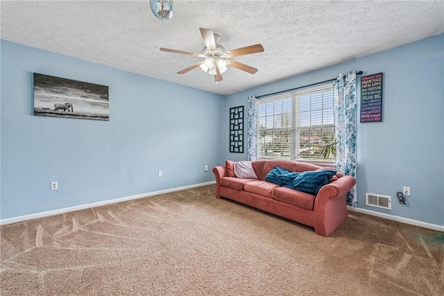 living area featuring carpet, visible vents, baseboards, and a ceiling fan