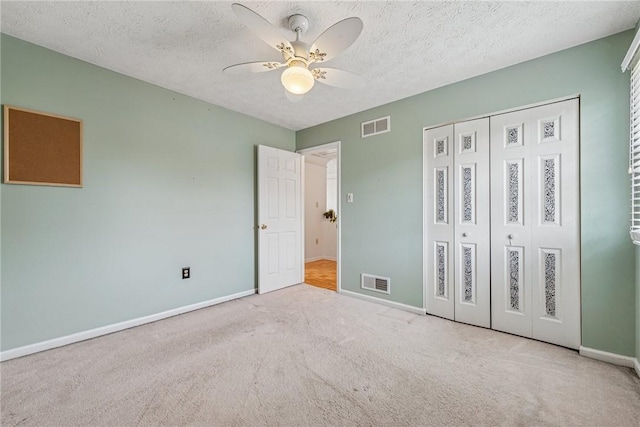 unfurnished bedroom featuring visible vents, baseboards, carpet flooring, and a closet