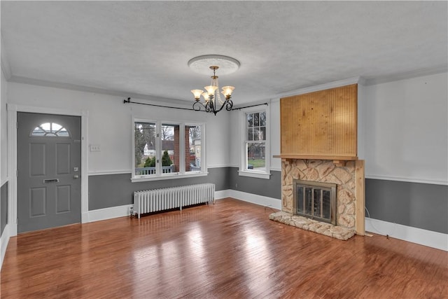115 Powell St, Wilkins Twp, PA 15112 - unfurnished living room featuring radiator heating unit, a chandelier, plenty of natural light, wood finished floors, and ornamental molding