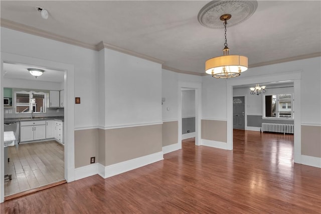 115 Powell St, Wilkins Twp, PA 15112 - unfurnished dining area featuring radiator, a chandelier, wood finished floors, crown molding, and a sink