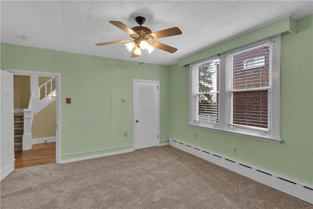 115 Powell St, Wilkins Twp, PA 15112 - unfurnished room with baseboard heating, carpet flooring, a ceiling fan, and stairway