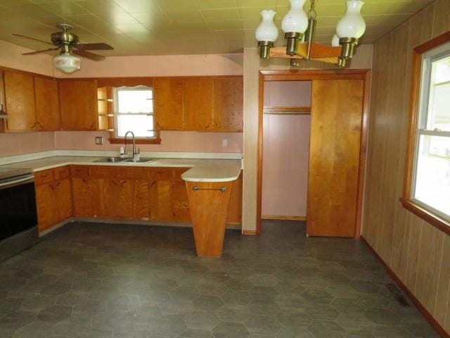 413 S 5th St, West Newton, PA 15089 - kitchen with stove, brown cabinetry, light countertops, wooden walls, and ceiling fan