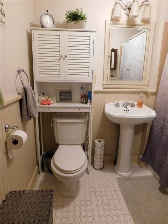 full bath featuring a wainscoted wall, a sink, and toilet