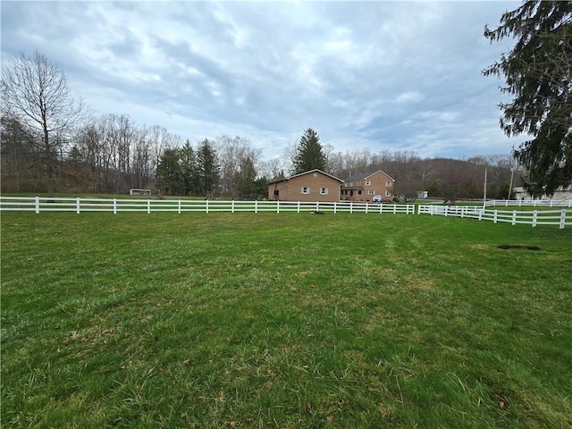 view of yard featuring fence and a rural view