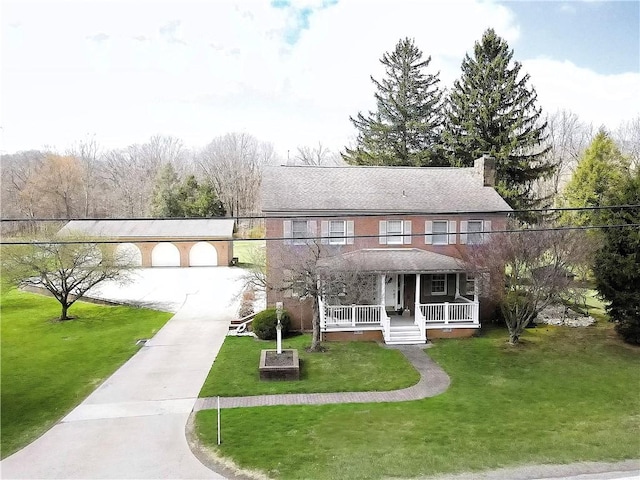 view of front facade with a front yard, a porch, and a chimney