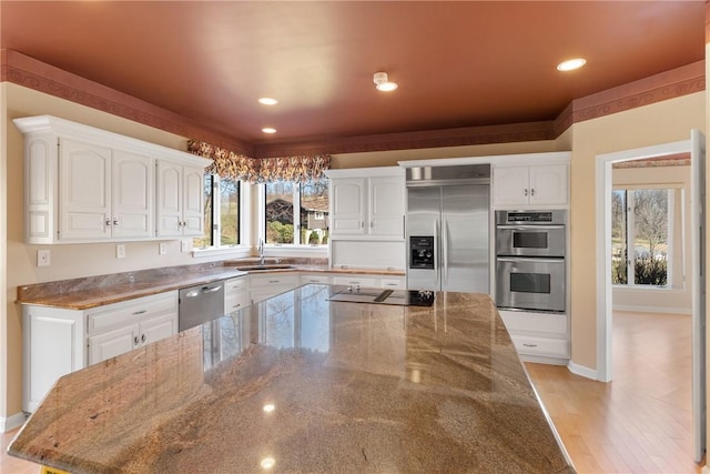2036 Revere Dr, Connellsville, PA 15425 - kitchen featuring stainless steel appliances, white cabinetry, dark stone counters, recessed lighting, and light wood-type flooring