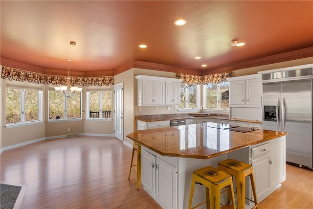 2036 Revere Dr, Connellsville, PA 15425 - kitchen featuring appliances with stainless steel finishes, a chandelier, a kitchen bar, plenty of natural light, and recessed lighting