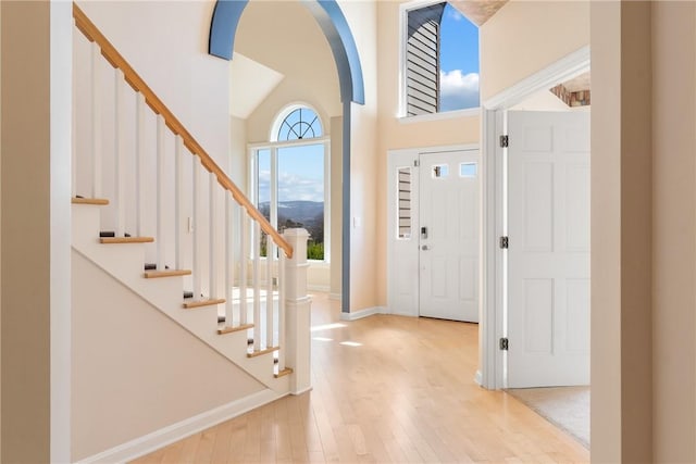 2036 Revere Dr, Connellsville, PA 15425 - foyer entrance featuring arched walkways, wood-type flooring, a towering ceiling, and stairs