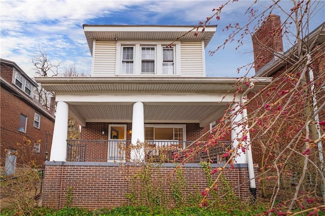view of front of house featuring covered porch and brick siding