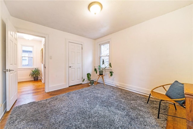 living area with baseboards and wood finished floors