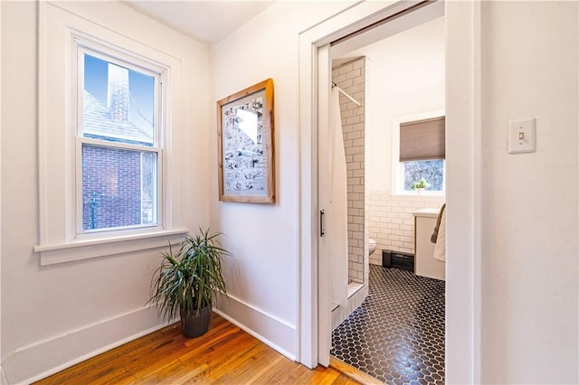 hallway featuring baseboards and wood finished floors