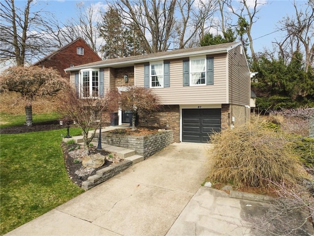 view of front of house featuring a front lawn, an attached garage, and concrete driveway