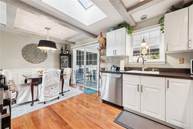 kitchen with beam ceiling, a sink, dishwasher, light wood-style flooring, and dark countertops