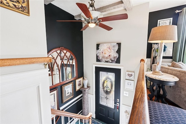 foyer featuring ceiling fan and beam ceiling